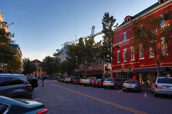 Brick storefronts and parked cars on a street in downtown Gainesville, Florida